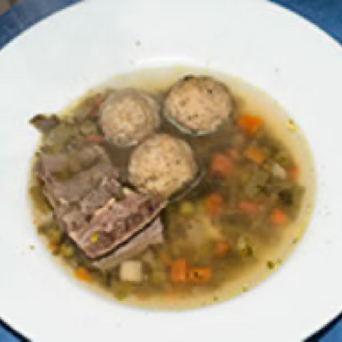 Ein Teller Markkl&ouml;&szlig;chensuppe mit drei Kn&ouml;deln, Fleischst&uuml;cken und Gem&uuml;sew&uuml;rfeln.