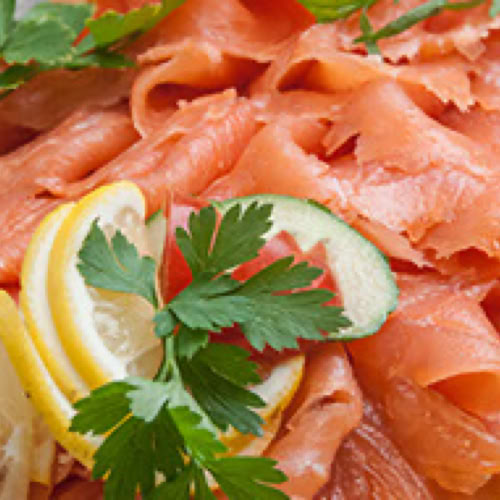 Ger&auml;ucherter Lachs mit Zitronenscheiben und Petersilie garniert.